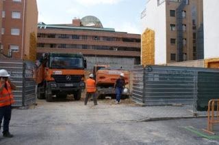Interior de una obra con trabajadores y grúas